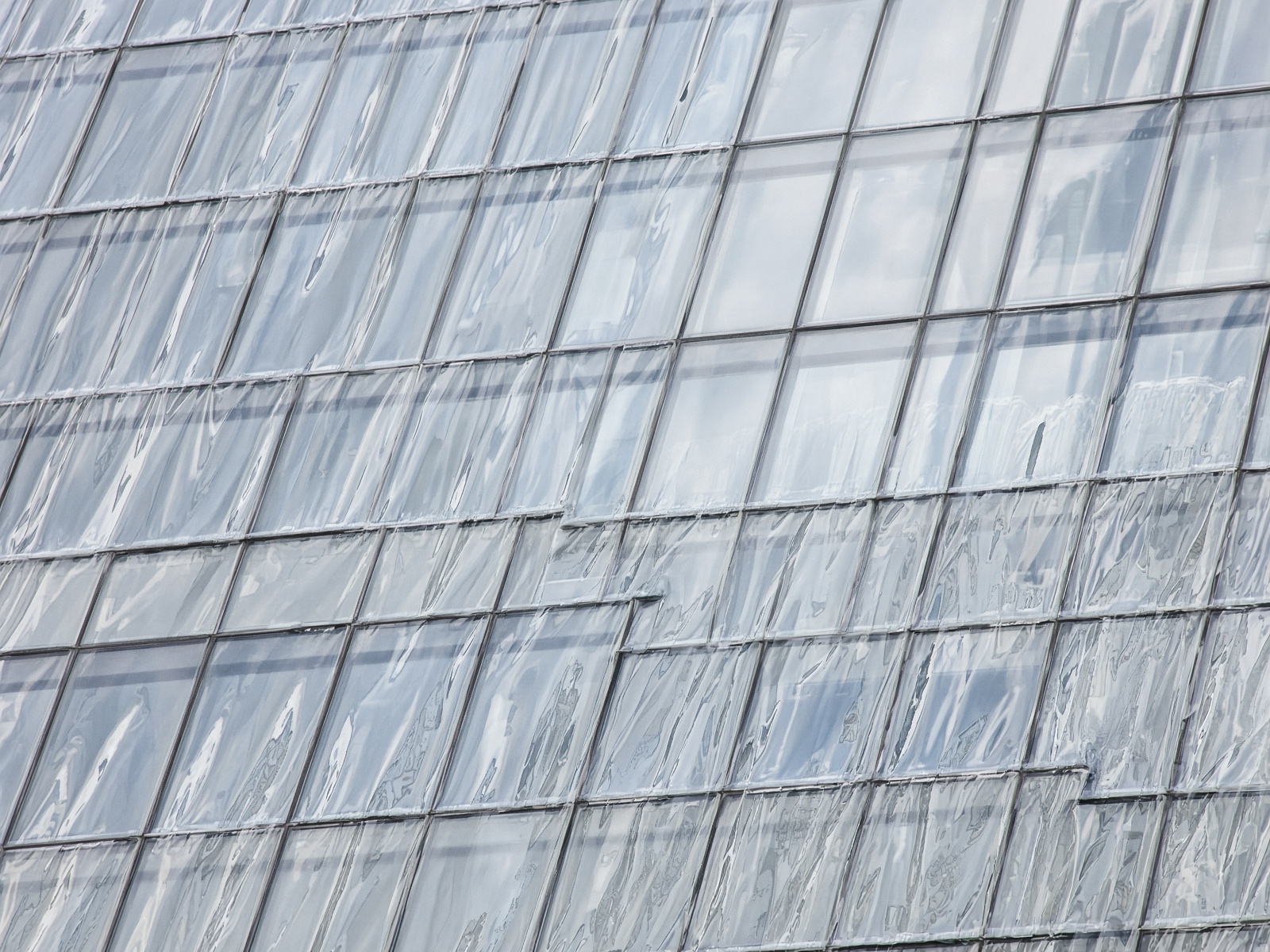 Glass curtain wall after rain, water sheeting off in clean films